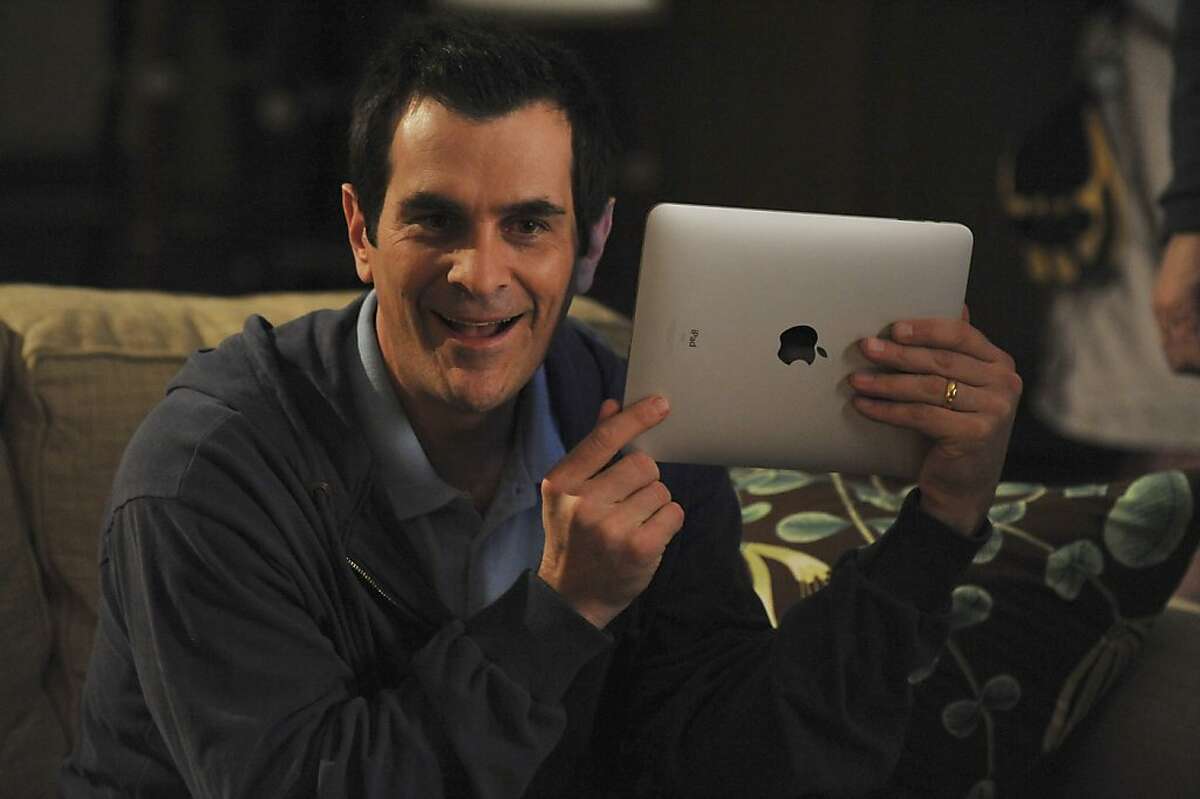 In this publicity image released by ABC, Ty Burrell who portrays Phil Dunphy is shown with the Apple iPad in an episode of Modern Family.